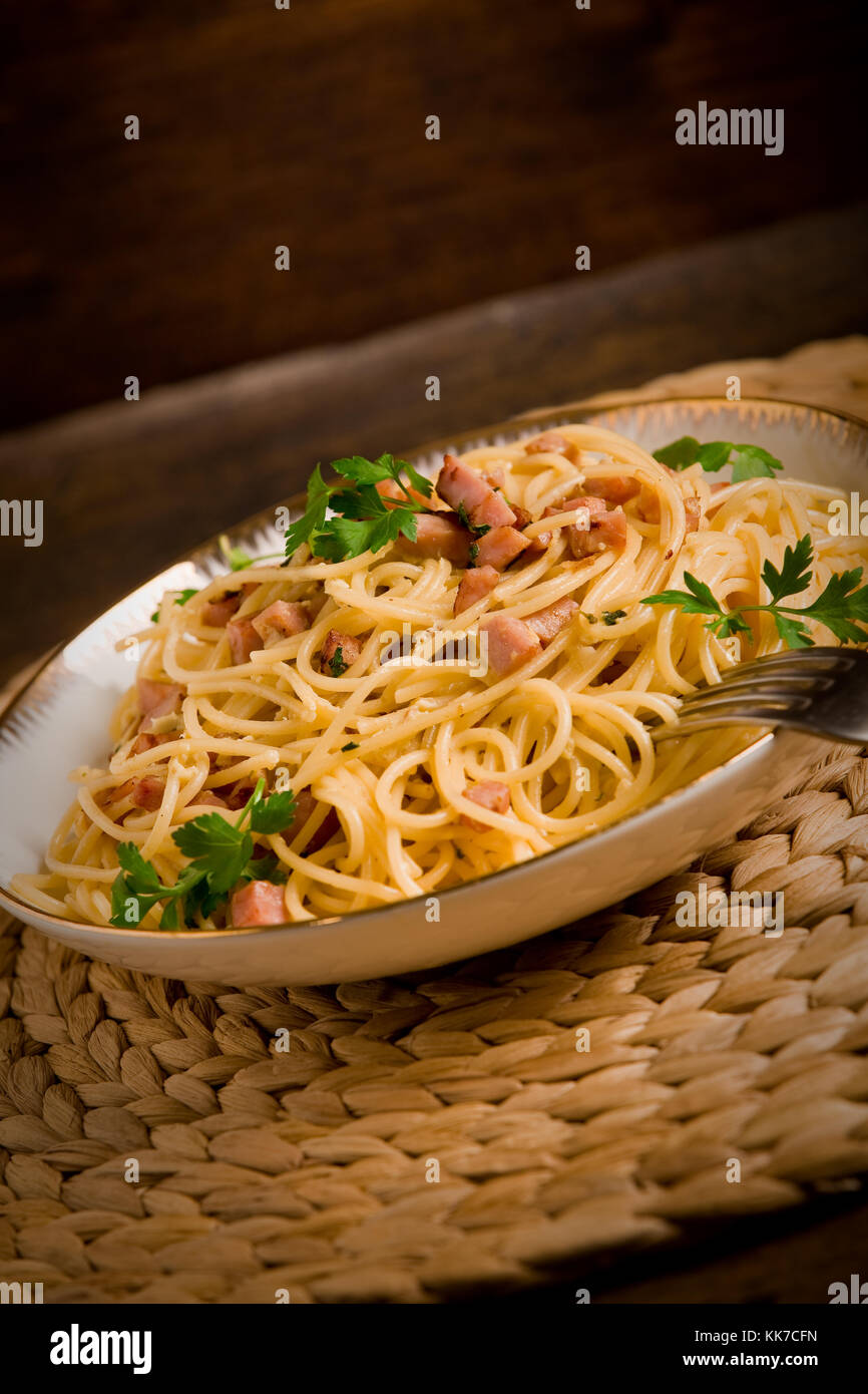 Delicious spaghetti with bacon and egg called alla carbonara on wooden