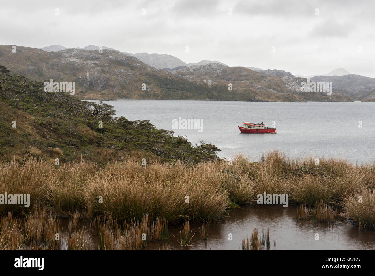 Boat moored off a remote island in southern chilean fjords Stock Photo