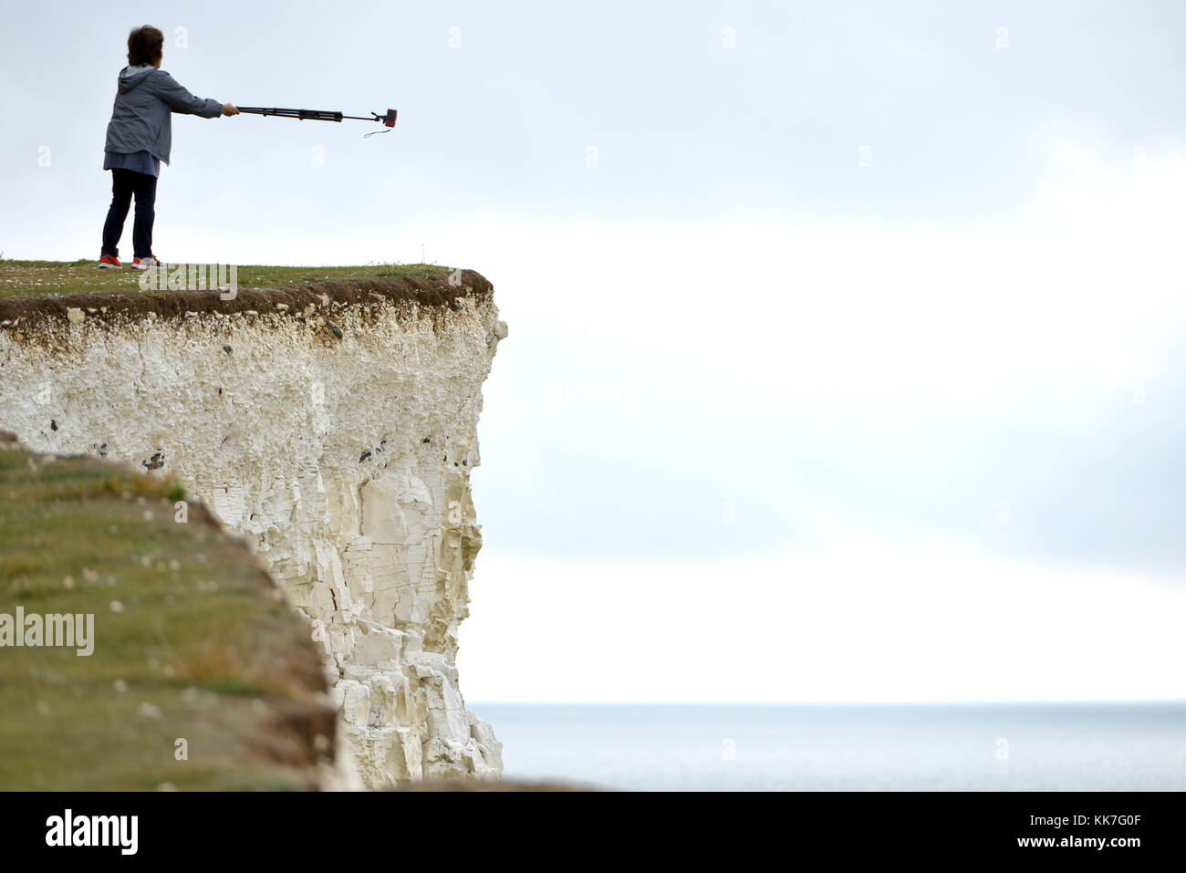 Tourists taking risks on cliff edges to get selfies, Beachy Head, Seven Sisters, East Sussex, UK Stock Photo