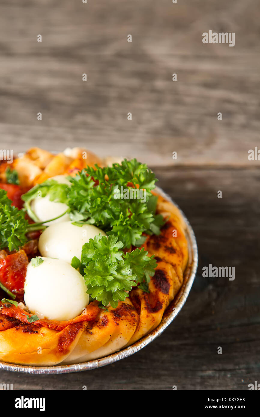 Pie in the oriental style. Filo pastry with tomato and mozzarella. Dark