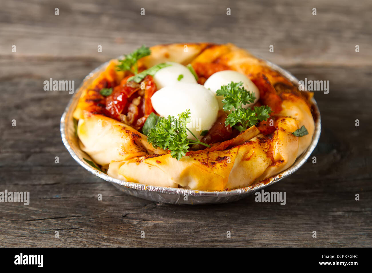 Pie in the oriental style. Filo pastry with tomato and mozzarella. Dark