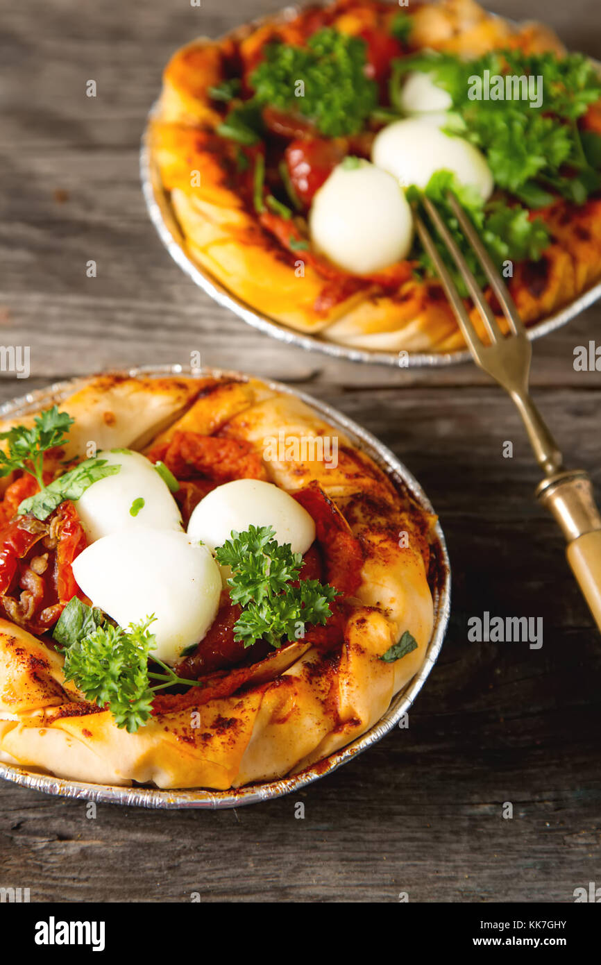 Pie in the oriental style. Filo pastry with tomato and mozzarella. Dark