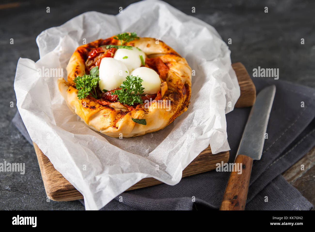 Pie in the oriental style. Filo pastry with tomato and mozzarella. Dark