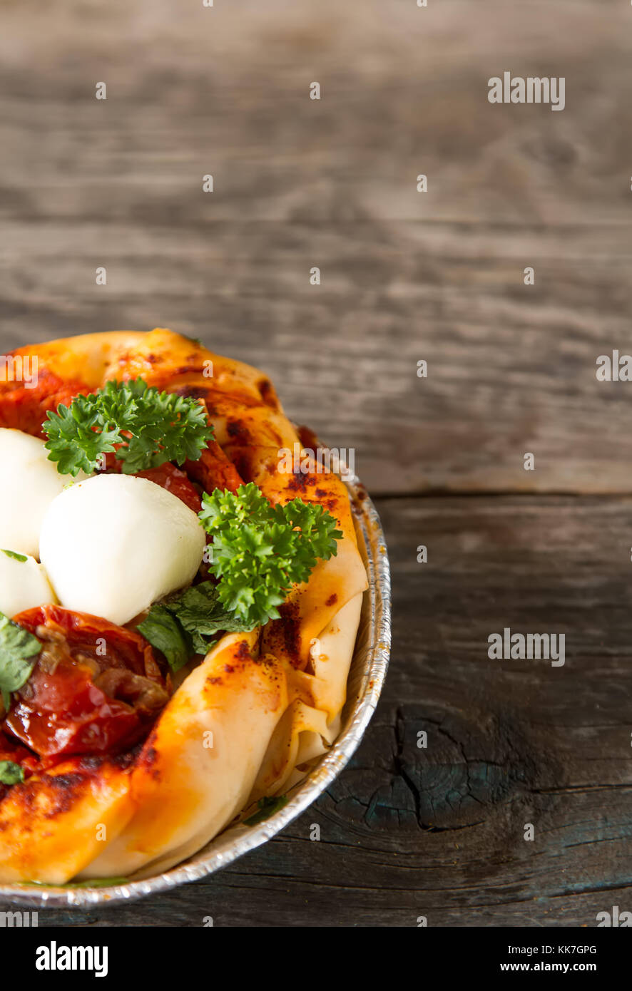 Pie in the oriental style. Filo pastry with tomato and mozzarella. Dark