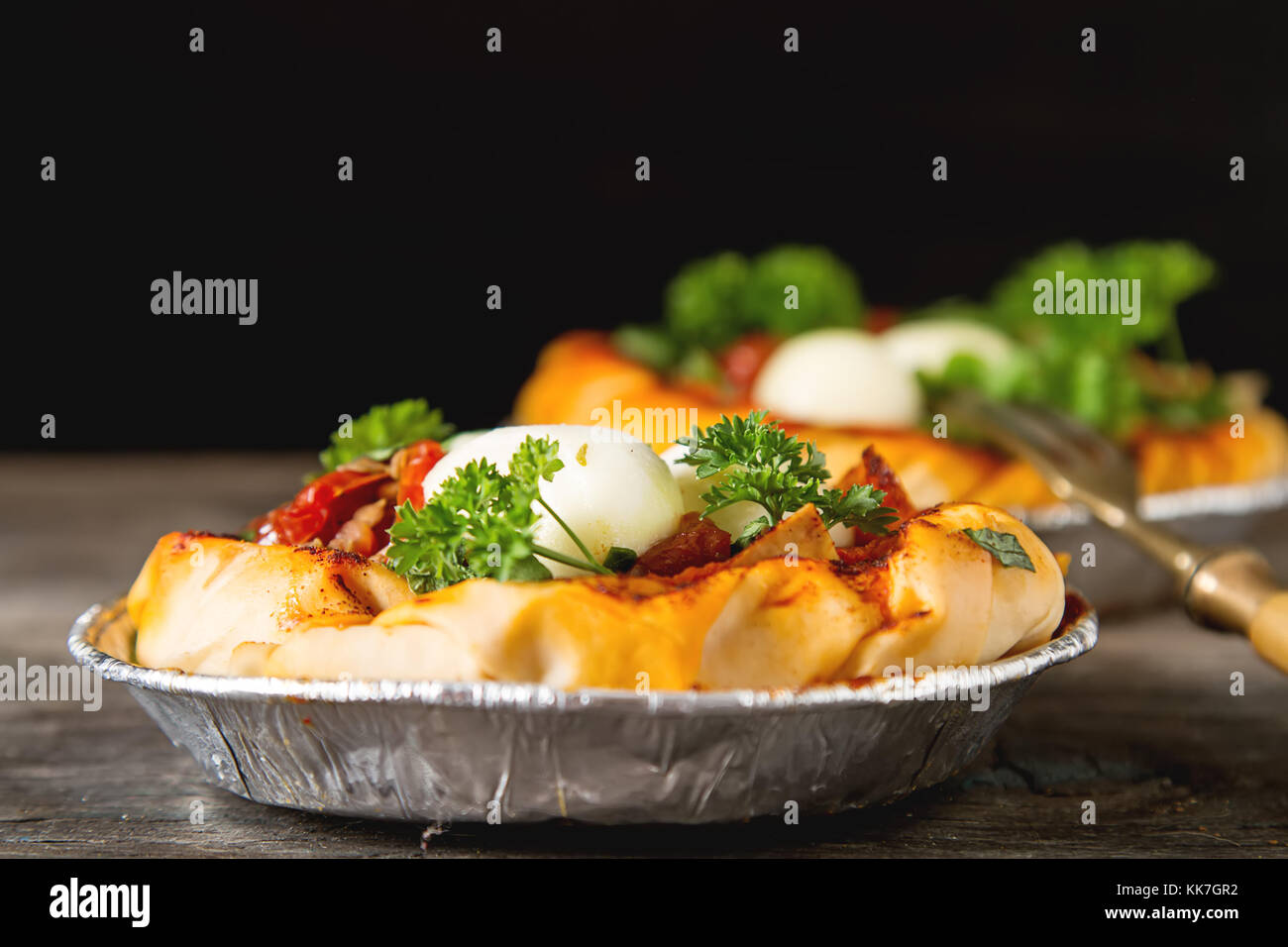 Pie in the oriental style. Filo pastry with tomato and mozzarella. Dark