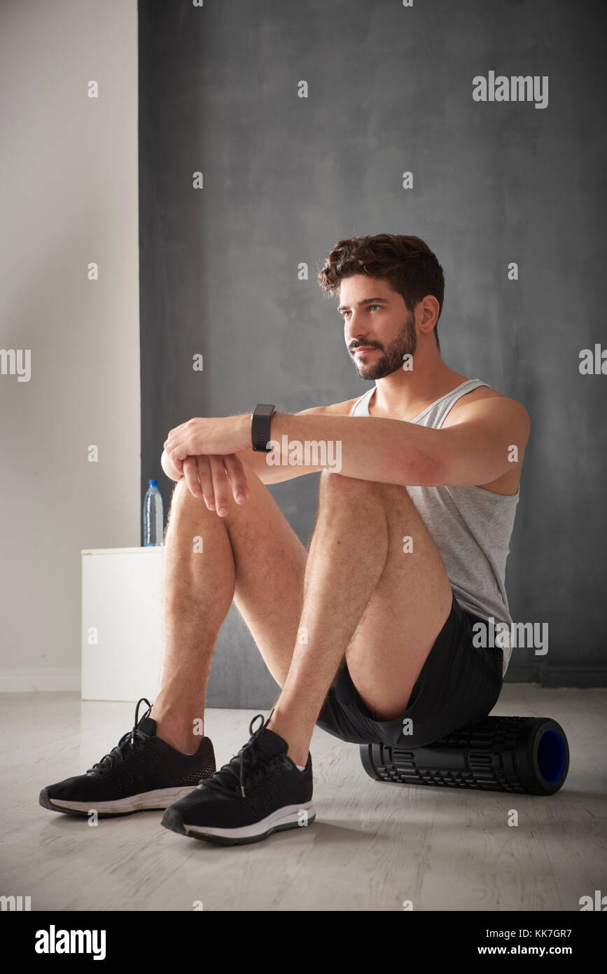 Shot of a young man using foam roller at the gym. Stock Photo