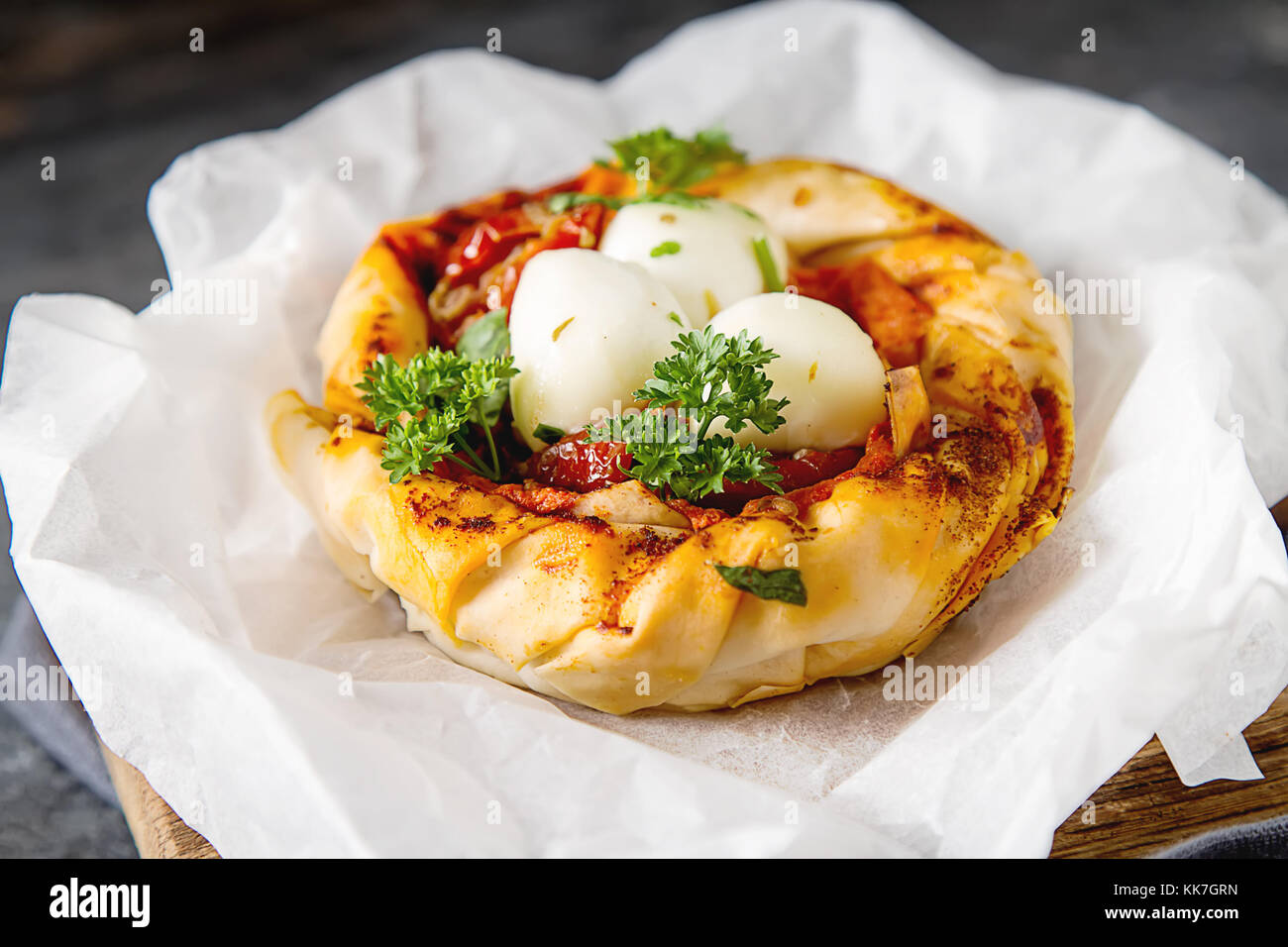 Pie in the oriental style. Filo pastry with tomato and mozzarella. Dark
