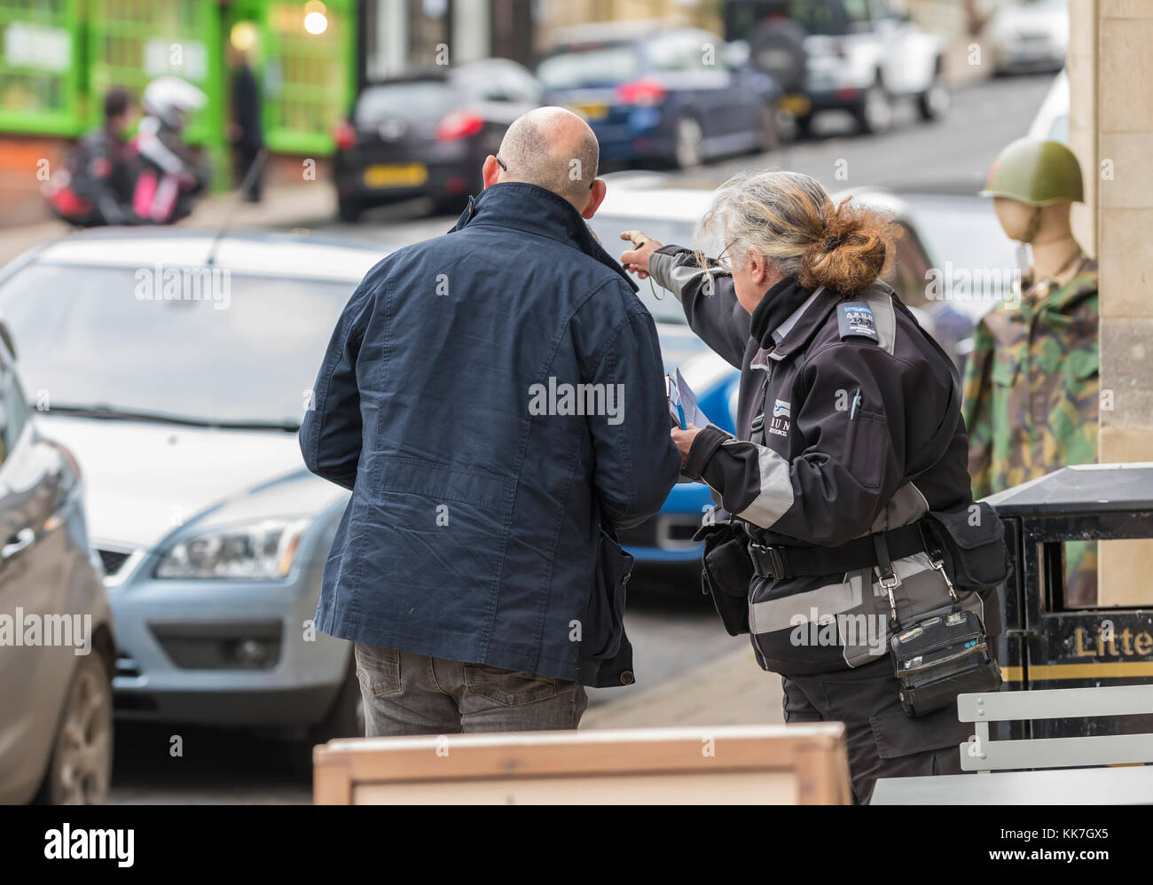 Female parking warden assisting a man asking for directions. Stock Photo