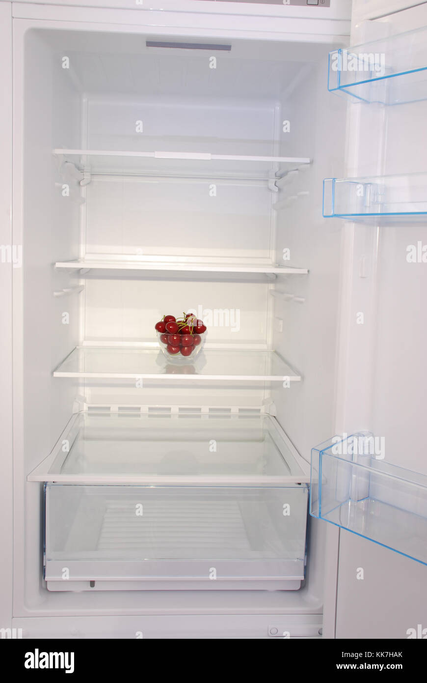 Cherries in open empty refrigerator. Weight loss diet concept Stock
