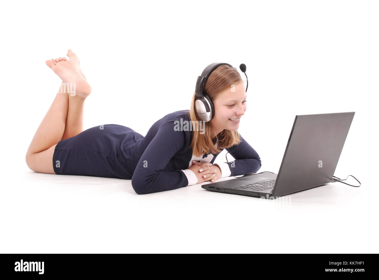 Pretty young teenage girl with laptop lying on the floor and headphones. isolated on white Stock Photo