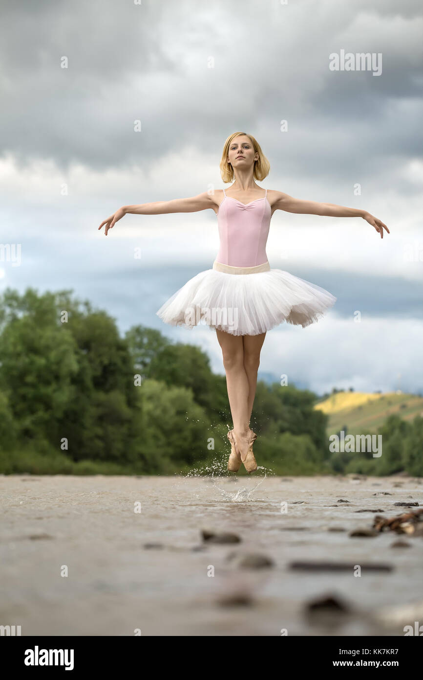 Ballerina jumping above river Stock Photo