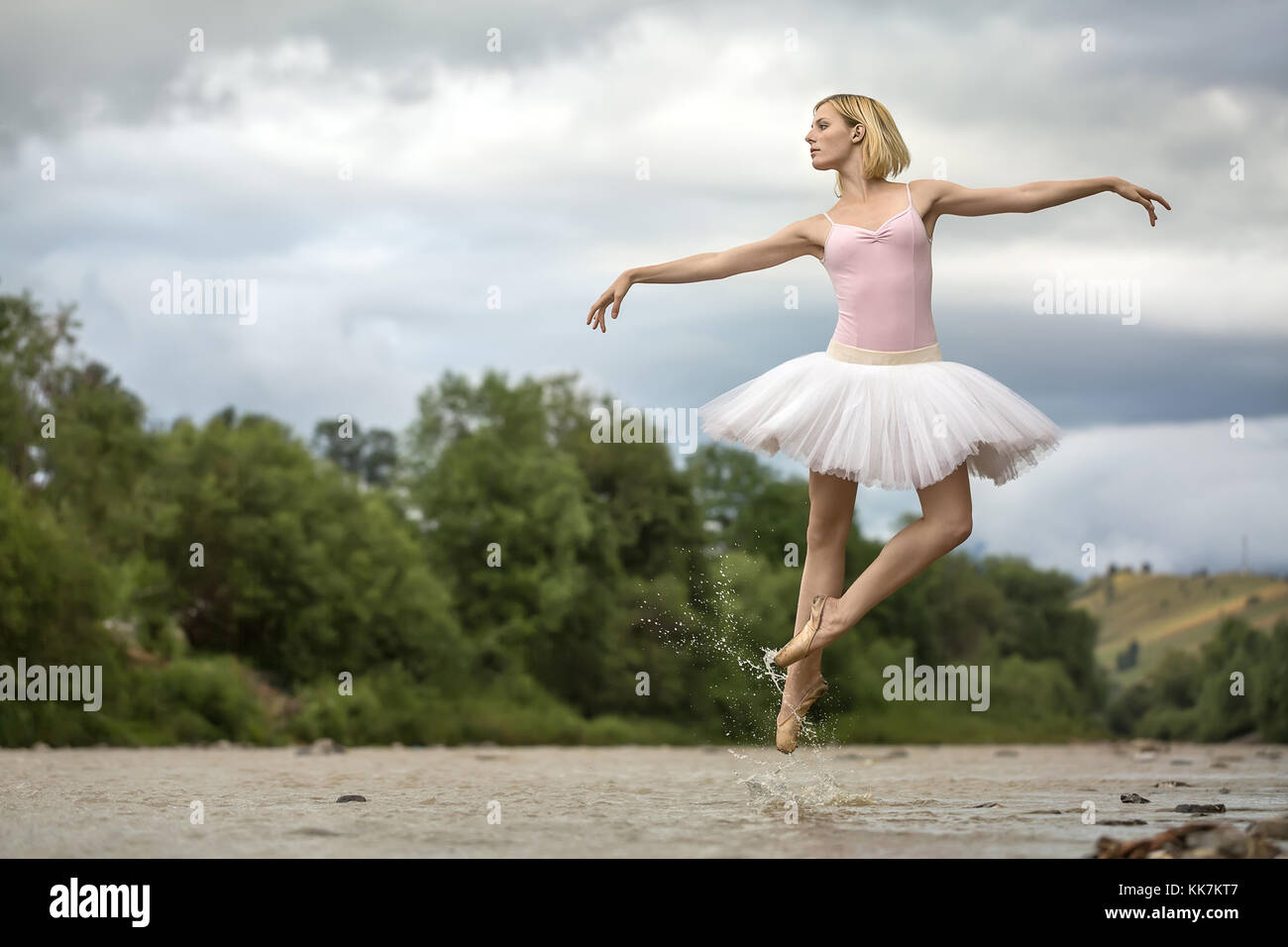 Ballerina jumping above river Stock Photo