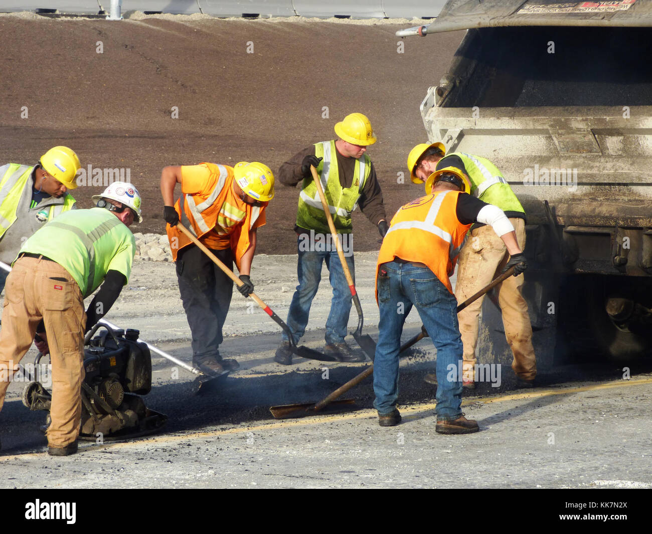During a weekend closure of eastbound SR 520, crews place fresh asphalt to repair roadway sections of eastbound SR 520. Teamwork makes the dream work – 101417 37089792263 o Stock Photo