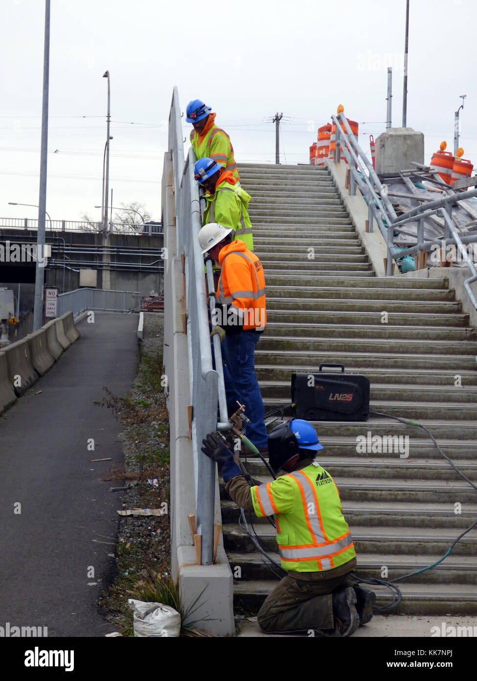During the full closure on Jan. 28, crew members work together to install the new handrail along the path between the westbound SR 520 flyer stop and Montlake Boulevard. 12817 - Teamwork makes the dream work 31802421573 o Stock Photo