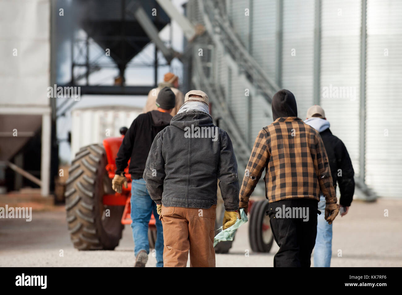 THREE GENERATIONS OF FARMERS WALKING ACROSS DRIVEWAY OF THE FAMILY FARM