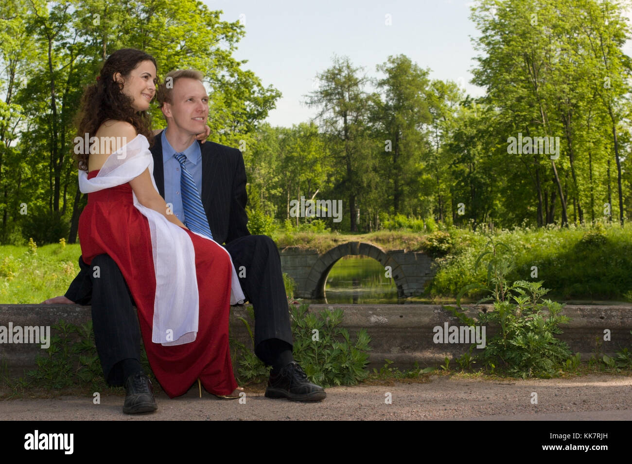 Happy young couple sitting in park Stock Photo - Alamy