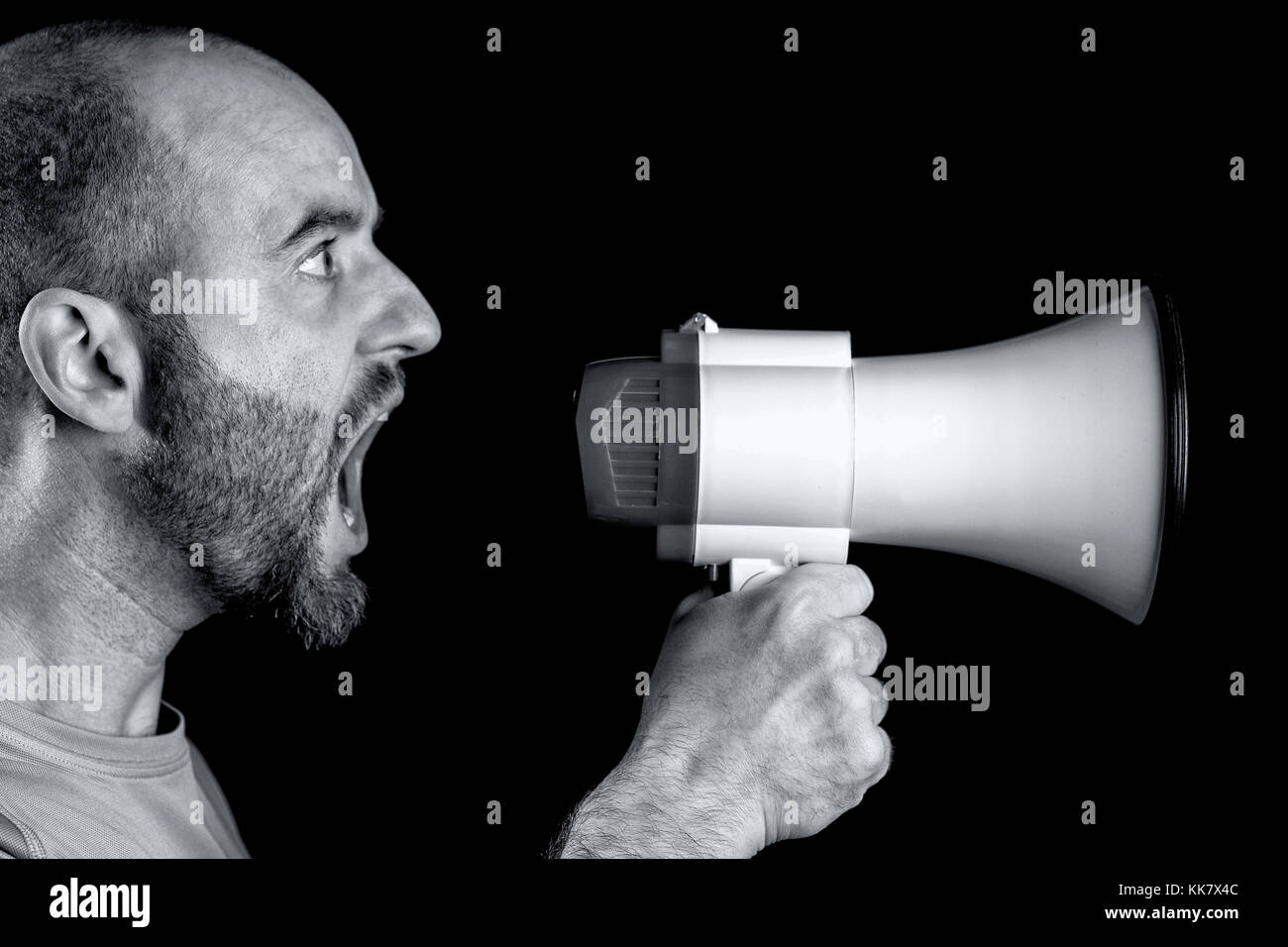 man shouting into megaphone black background Stock Photo