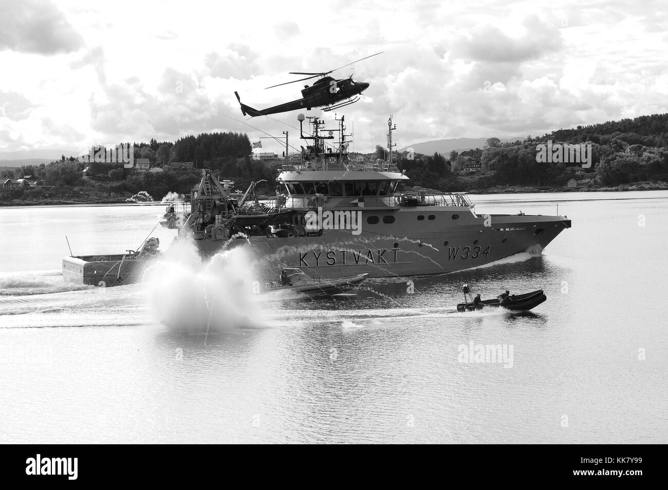 The crew of Royal Norwegian Coast Guard patrol boat KV Tor W334 simulates being a skiff taken over by pirates as Royal Norwegian Marinejaggers use rigid hull inflatable boats and a helicopter to storm the skiff and regain control from the pirates during a live demonstration of the Norwegian navy's special operations unit's capabilities, Bergen, Norway, 2012. Image courtesy Mass Communication Specialist 1st Class Peter D. Lawlor/US Navy. Stock Photo