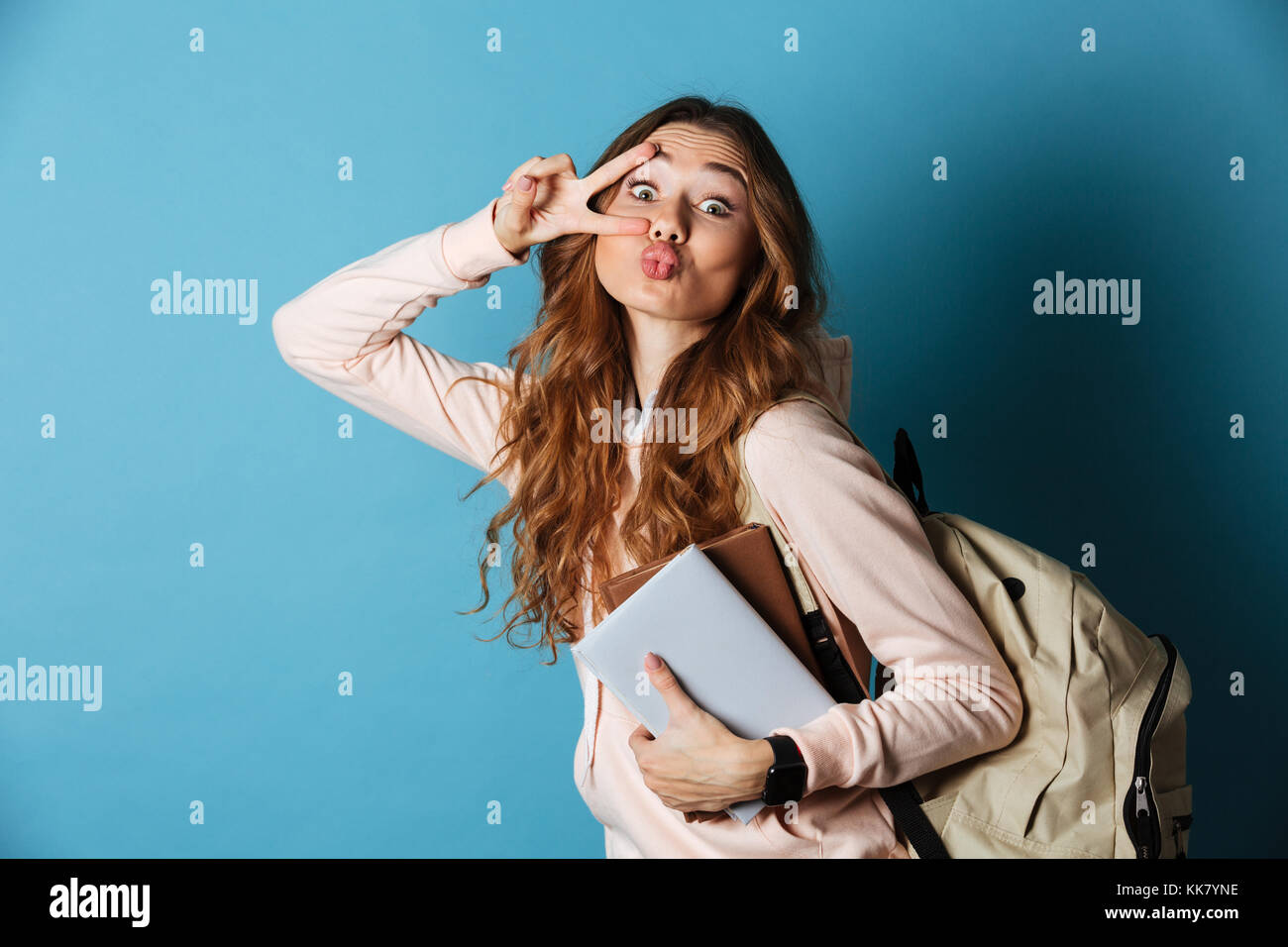 Portrait of a happy pretty girl student with backpack holding books and ...