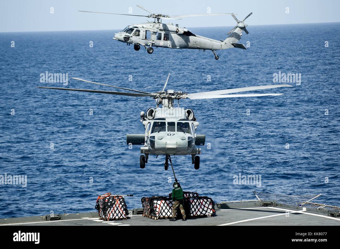 MH-60S Sea Hawk helicopters from the Island Knights of Helicopter Sea Combat Squadron HSC 25 lift supplies from the fantail of the Military Sealift Command s dry cargo and ammunition ship USNS Amelia Earhart T-AKE 6 before delivering them to the aircraft carrier USS George Washington CVN 73, Pacific Ocean, 2012. Image courtesy Mass Communication Specialist 3rd Class Paul Kelly/US Navy. Stock Photo