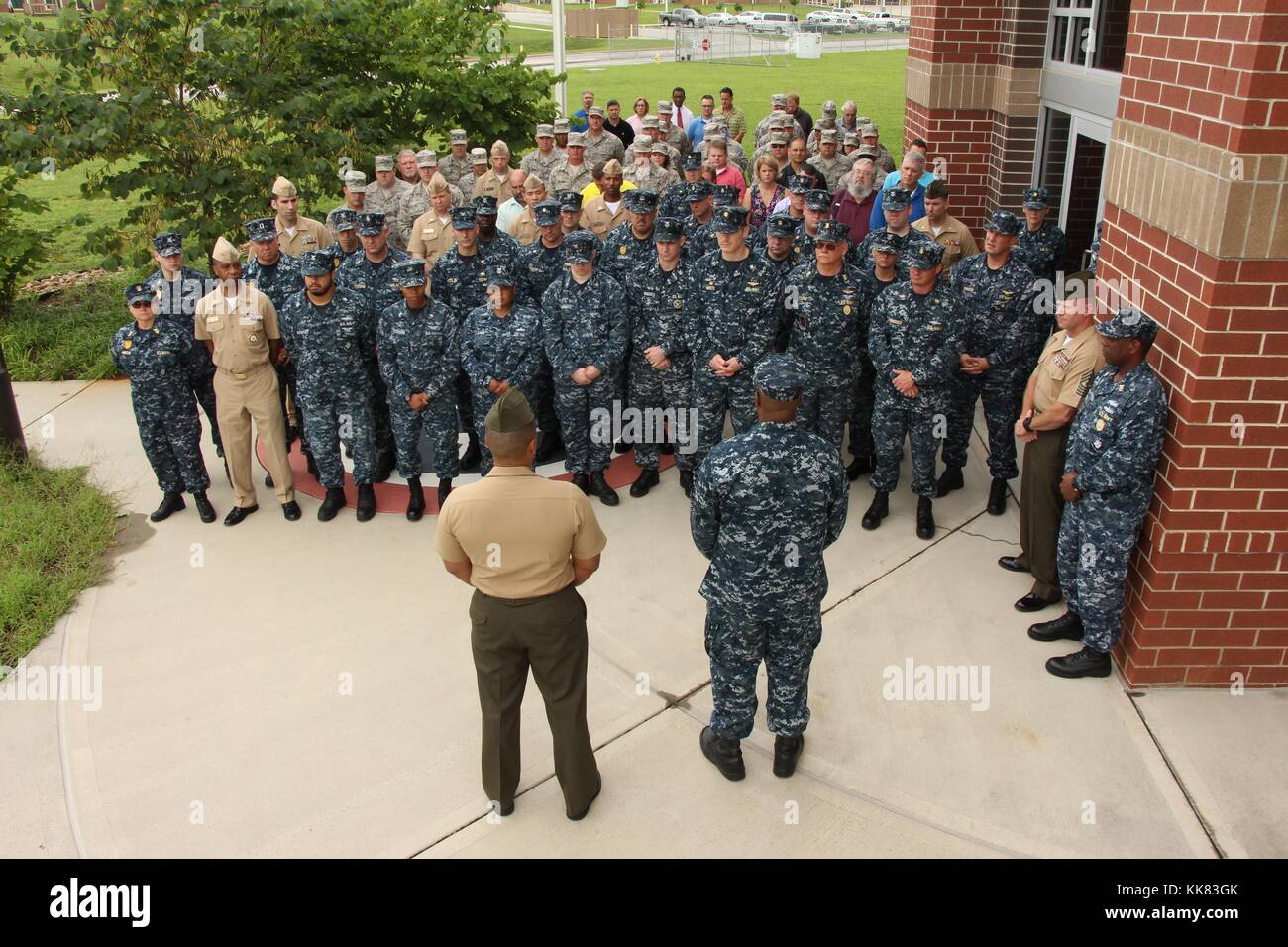 Rear Admiral Eric Coy Young, commander of Navy Reserve Forces Command, and Lt Col Alvin Bryant, an inspector and instructor with the 3rd Battalion, 14th Marines, address Sailors, Airmen, and Marines before a moment of silence to honor the five service members killed July 16 in an active shooter attack at the Navy Operational Support Center in Chattanooga, Tennessee, photo taken in Hattanooga, Tennessee. Image courtesy Logistics Specialist 1st Class America Henry/US Navy, 2015. Stock Photo