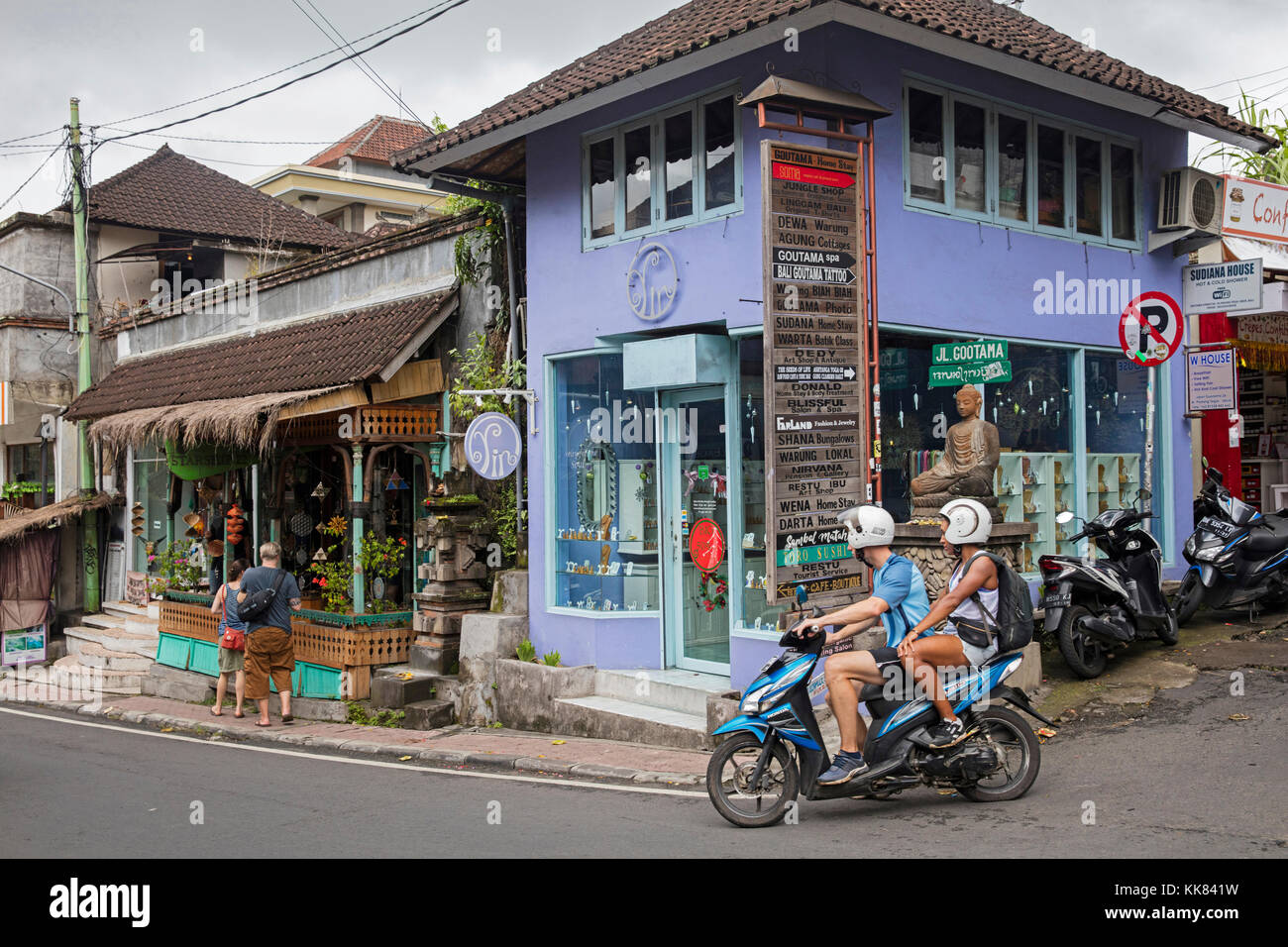 Western tourists riding motorbike in the village Ubud, Gianyar regency on the island Bali, Indonesia Stock Photo