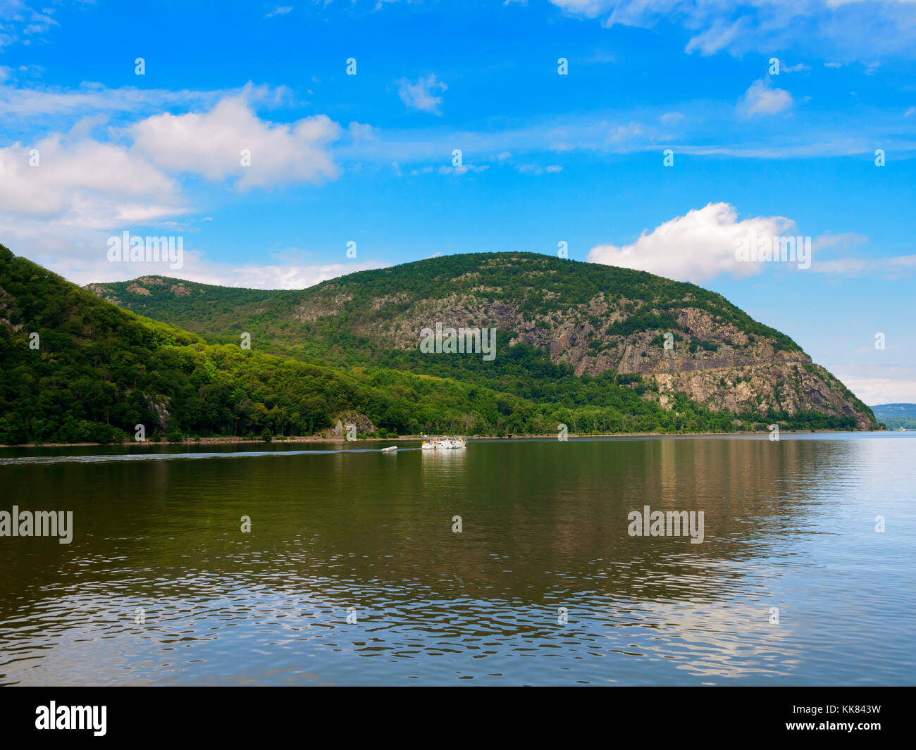 A sailboat with the mast stepped motors past Storm King Mountain, Hudson River, New York Stock Photo