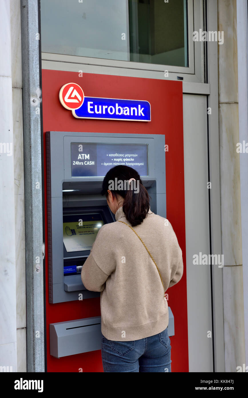 Woman at Eurobank ATM cash machine, Greece Stock Photo