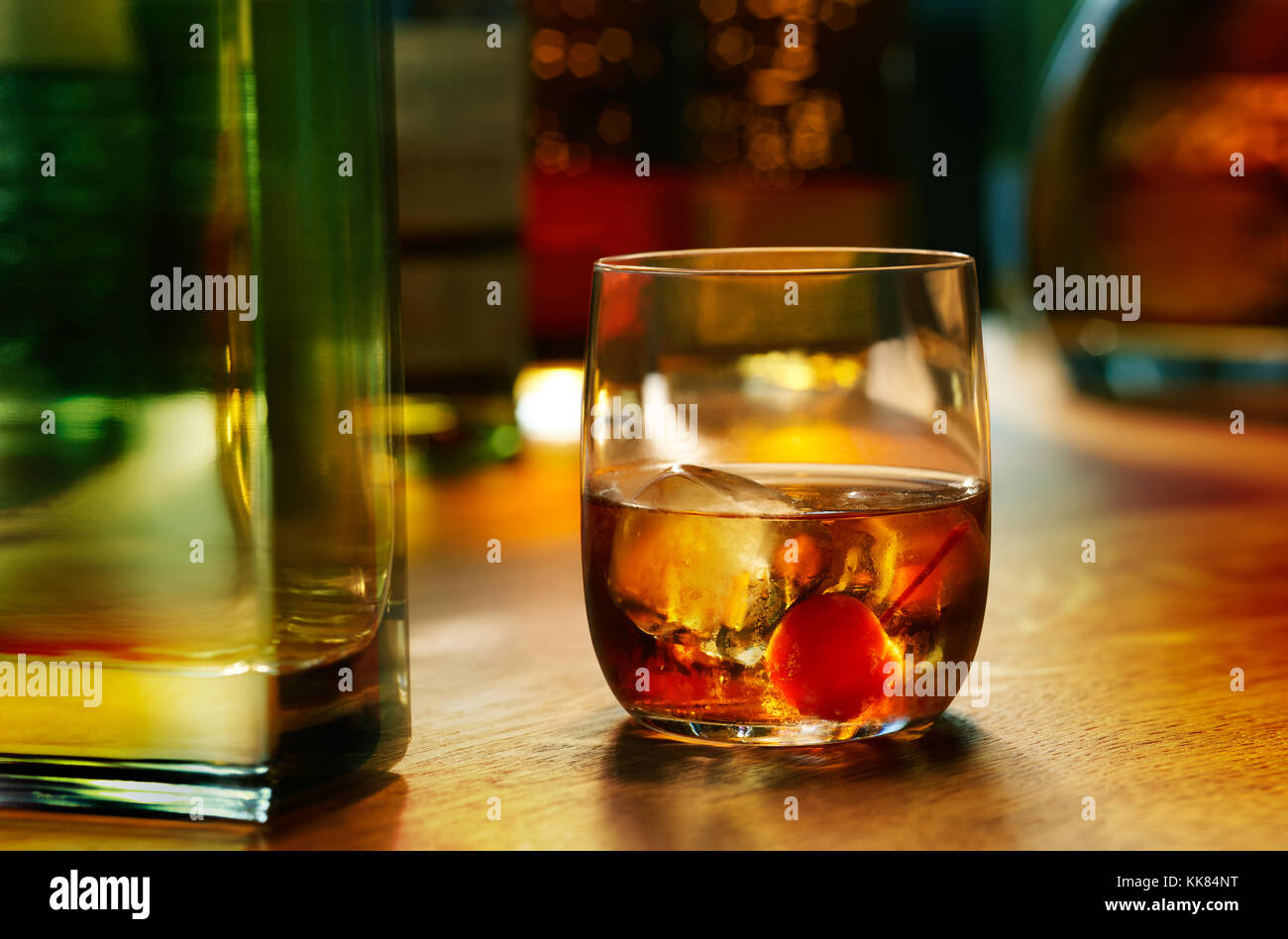 Warm bar lighting glowing through a happy hour Manhattan cocktail on