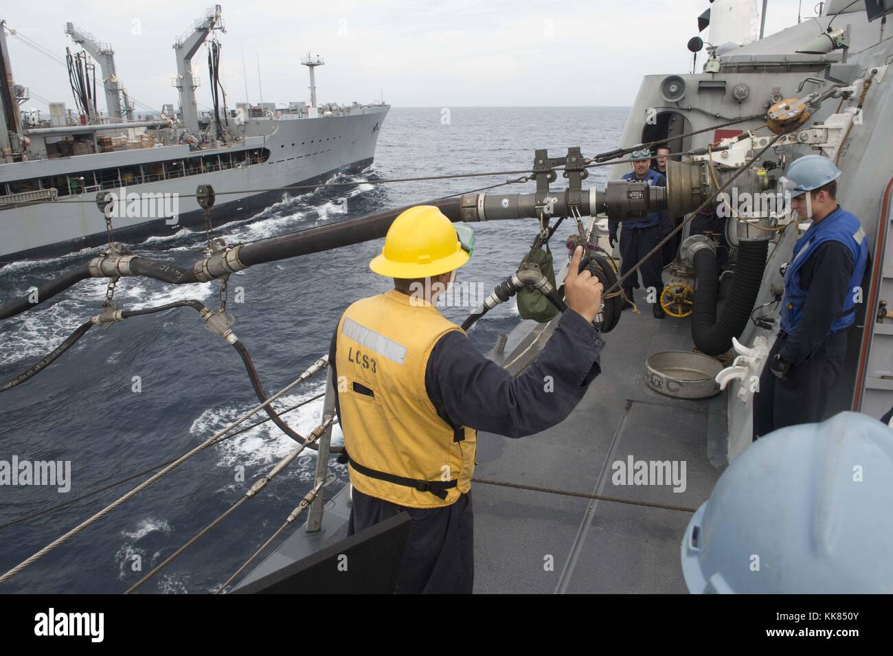 Sailors aboard the littoral combat ship USS Fort Worth connect a fuel line during a replenishment-at-sea exercise with the Military Sealift Command fleet replenishment oiler USNS Pecos T-AO 197 and the Republic of Singapore navy as part of Cooperation Afloat Readiness and Training CARAT Singapore 2015, South China Sea. Image courtesy Mass Communication Specialist 2nd Class Joe Bishop/US Navy, 2015. Stock Photo