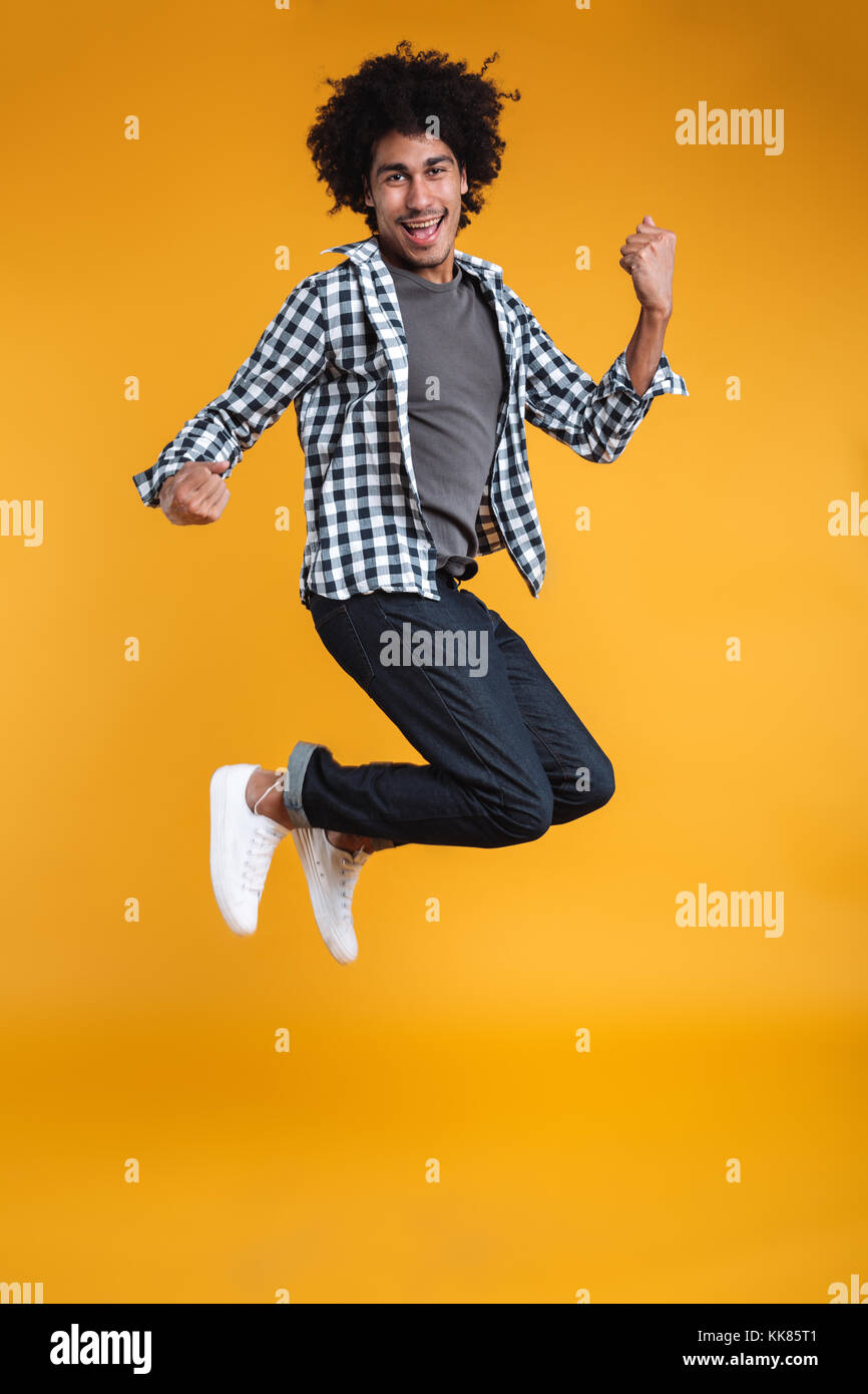 Full length portrait of a happy young african man jumping and ...