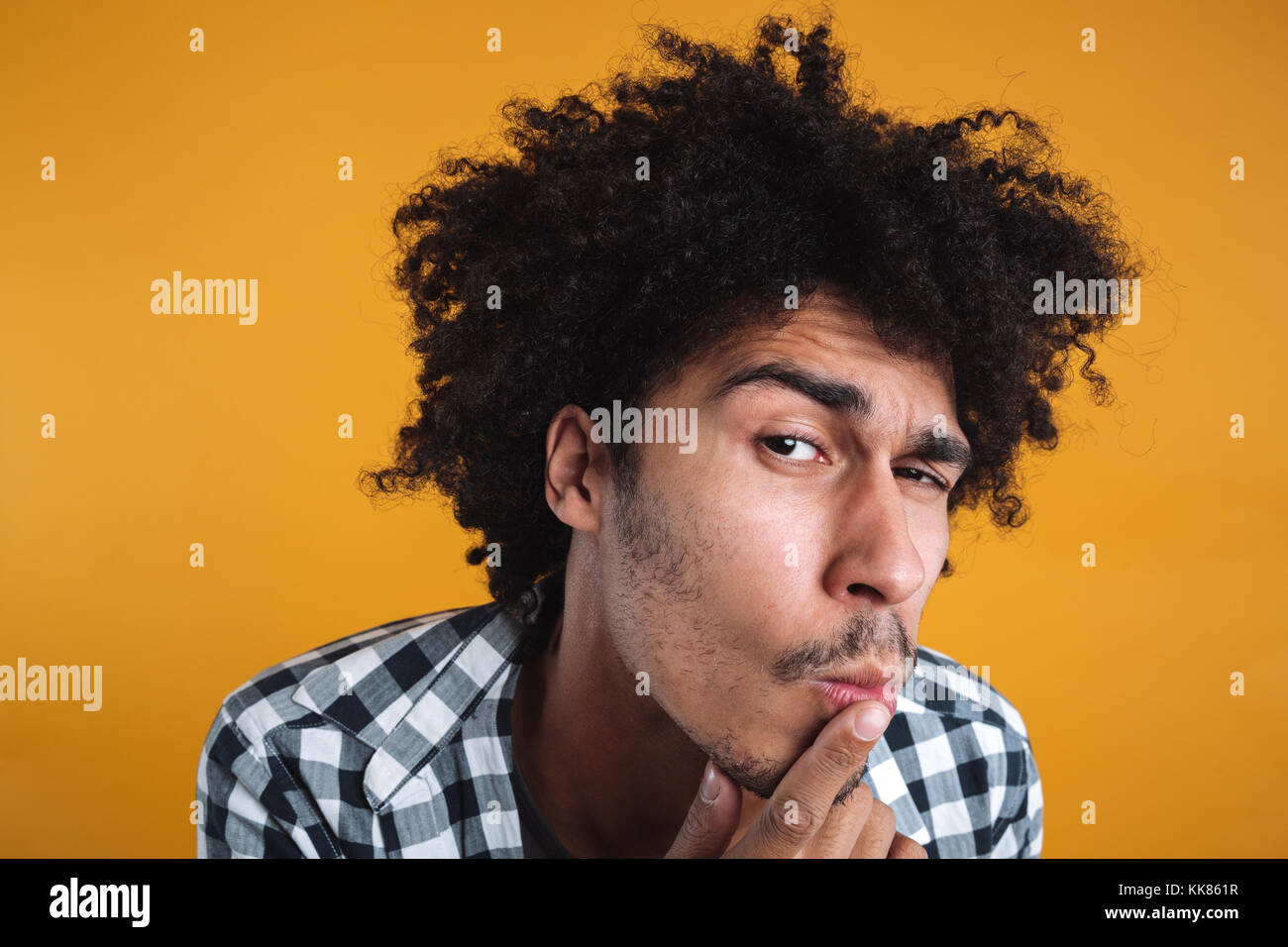 Close up portrait of a curious funny african man looking at camera