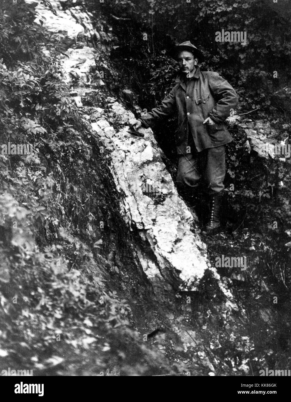 Prospector standing next to a gold-bearing quartz vein on the property of the Seward Bonanza Gold Mines Co during a gold rush, near mile 20 of the Alaska Northern Railway (Tustumena district, Cook Inlet region). Image courtesy USGS. September 11, 1911. Stock Photo