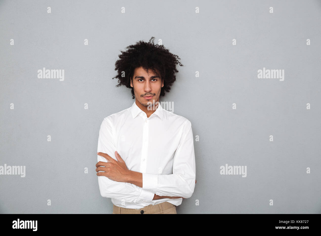 Portrait of a confident young african man in white shirt standing with ...