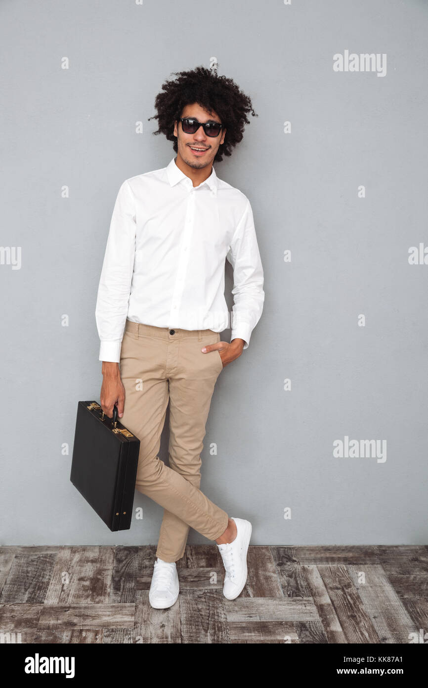 Full length portrait of a smiling confident african man in white shirt ...