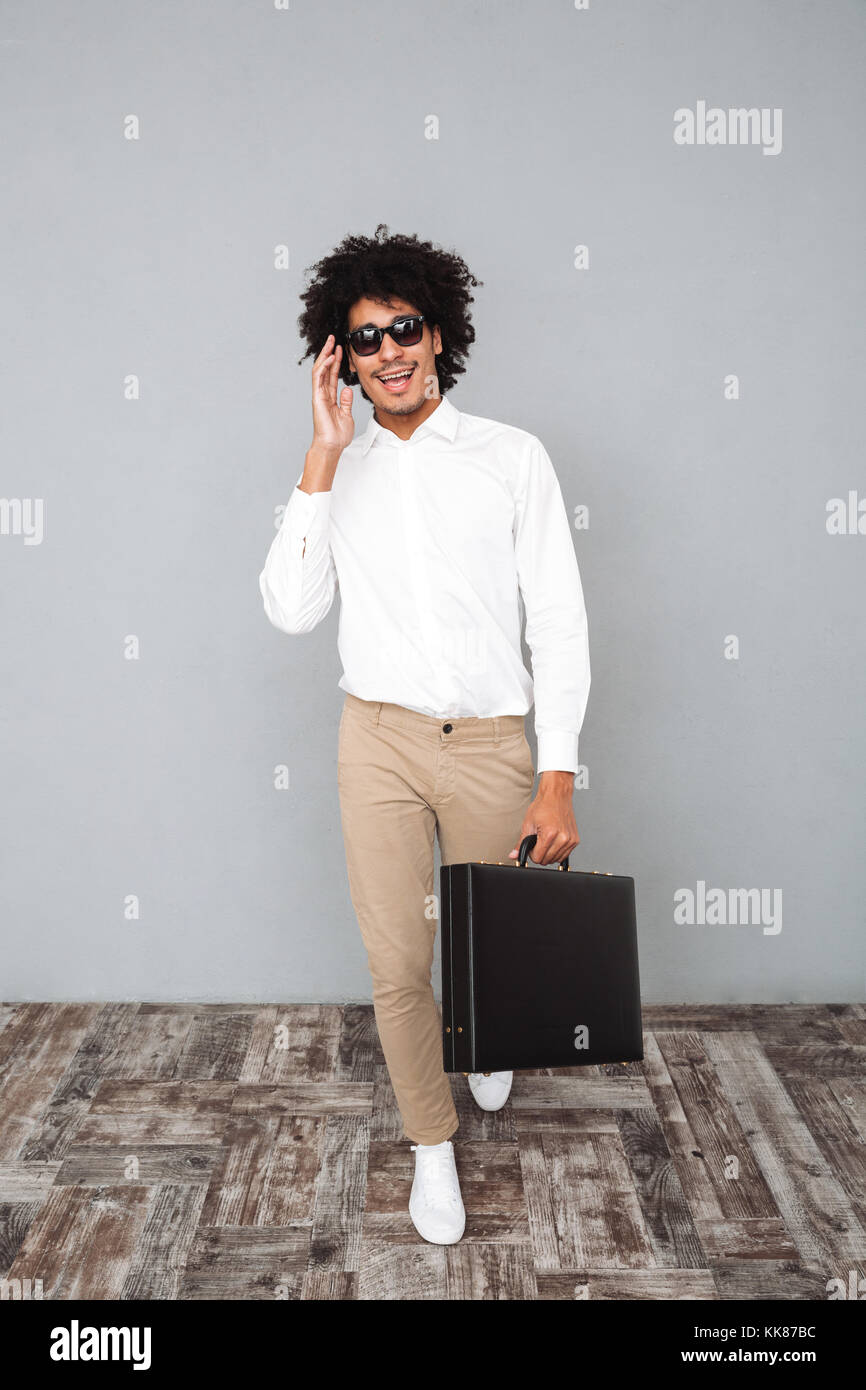 Full length portrait of a smiling confident african man in white shirt ...
