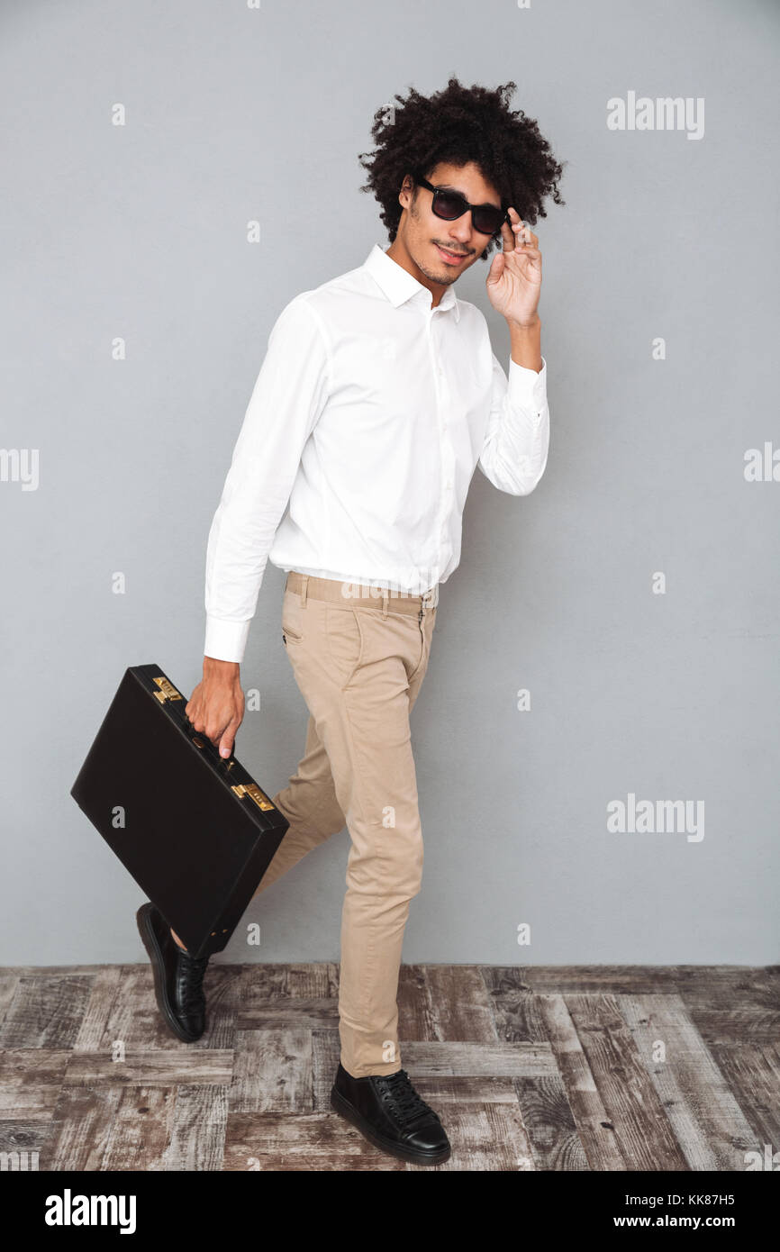 Full length portrait of a smiling confident african man in white shirt ...