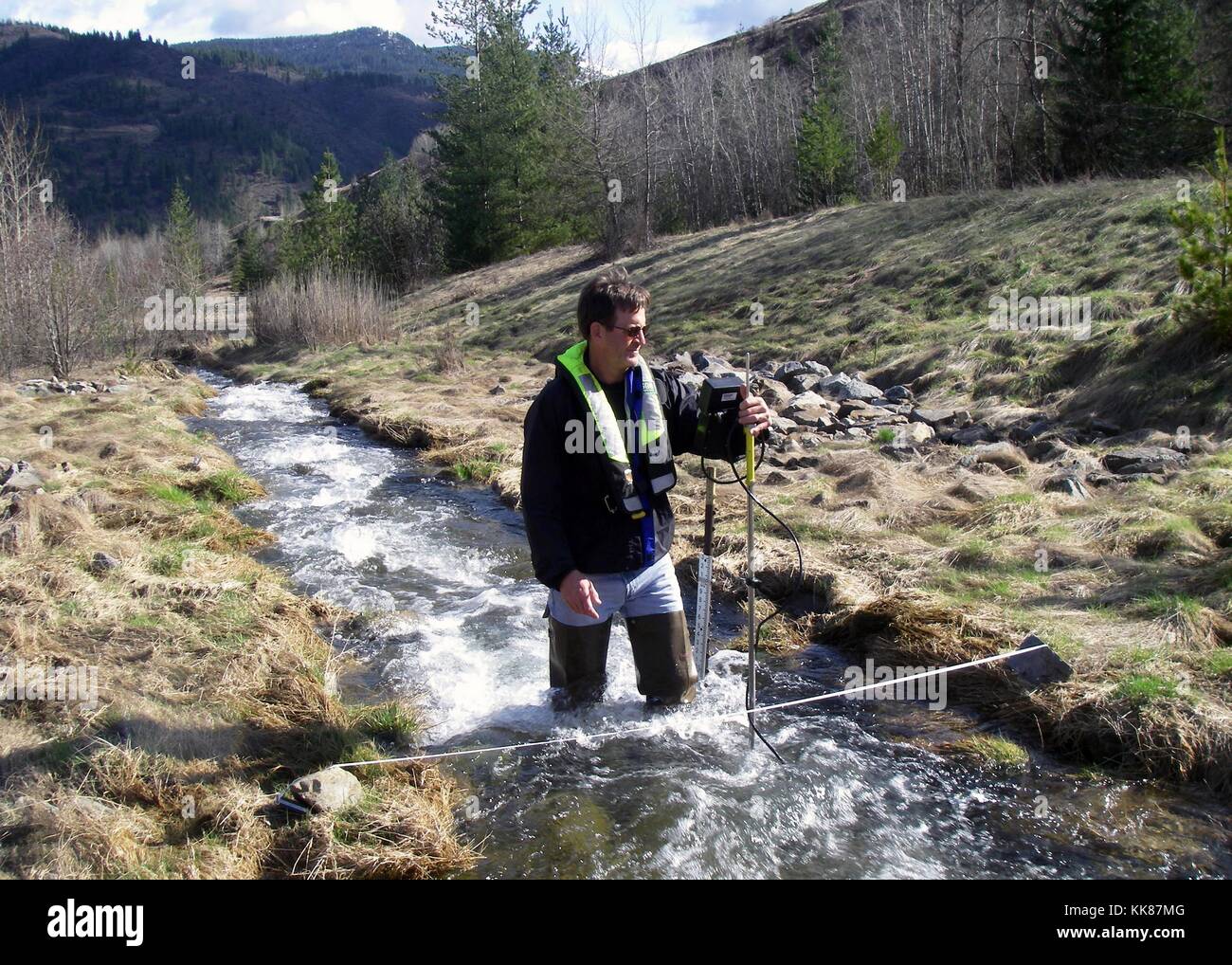 USGS hydrologist Greg Clark measures stream flow on Government Gulch Creek, a tributary to the Coeur d'Alene River in northern Idaho. Image courtesy Deena Green/USGS, 2014. Stock Photo
