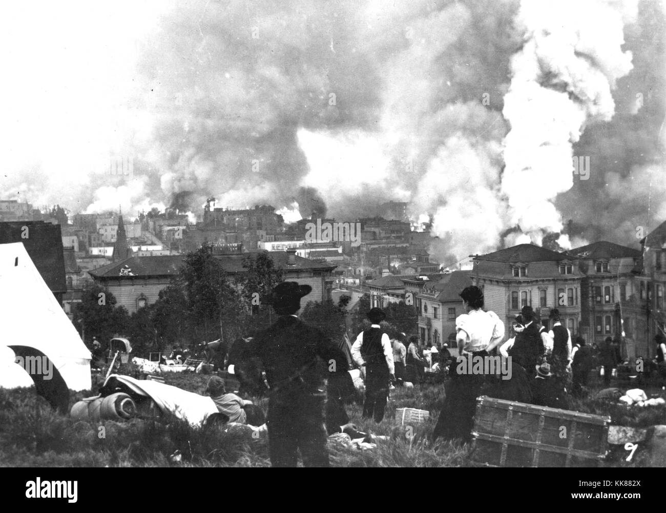 Residents overlooking downtown San Francisco as fires breakout across the city after the 1906 earthquake. The event that took place in 1906 measured equivalent to M7.9 and ruptured 296 miles along the San Andreas fault. Image courtesy USGS. 2014. Stock Photo