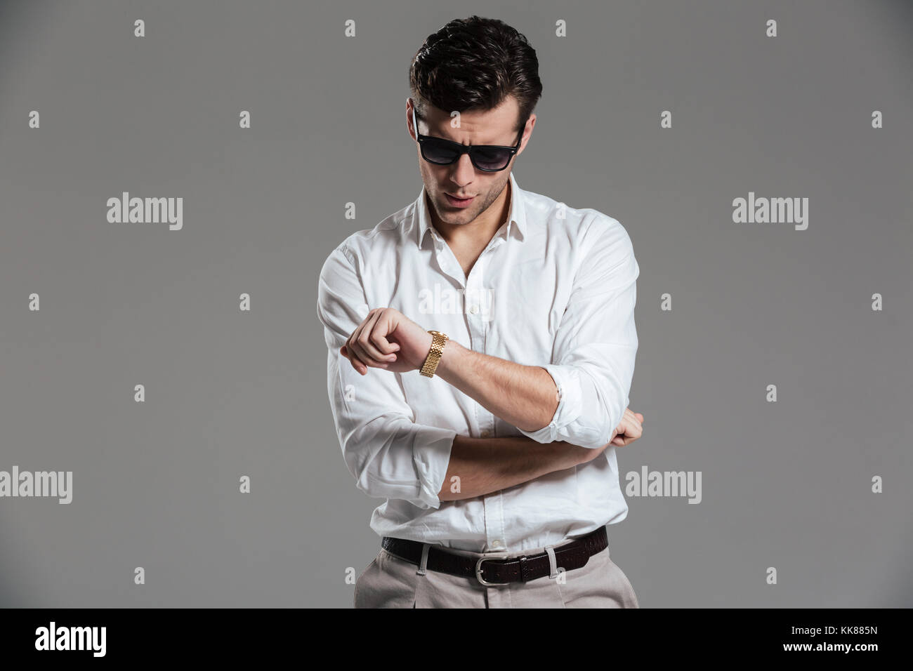 Portrait of a handsome young man dressed in white shirt wearing eyewear ...