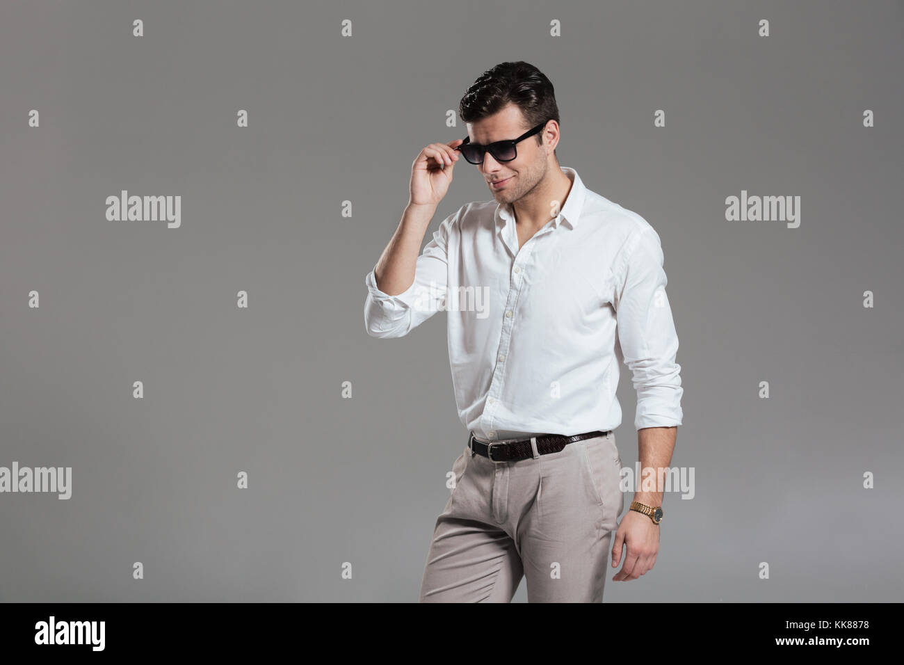 Portrait of a successful smiling man dressed in white shirt holding ...