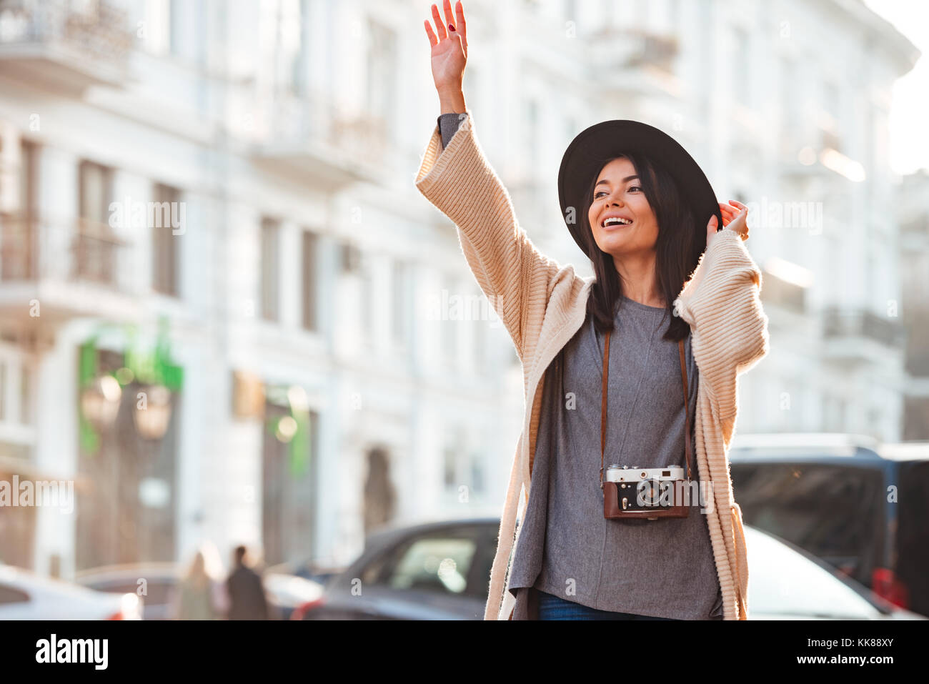 Beautiful asian woman in black hat catching taxi on city street Stock Photo