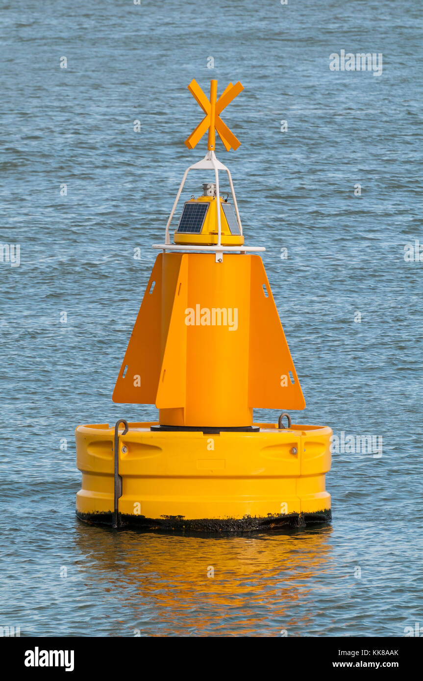 A yellow buoy is floating on the water surface in the Port of Rotterdam in the Netherlands. Stock Photo