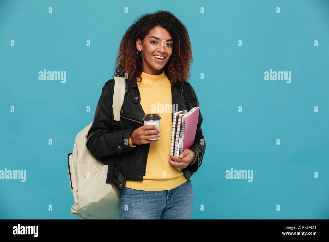 Photo of happy beautiful young african woman student standing isolated ...