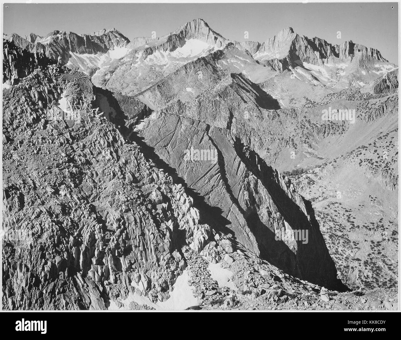 Black and white photograph of rocky mountain range, captioned 'Mount Brewer, Kings River Canyon (Proposed as a national park)', by Ansel Adams, from Photographs of National Parks and Monuments California, United States, 1936. Stock Photo