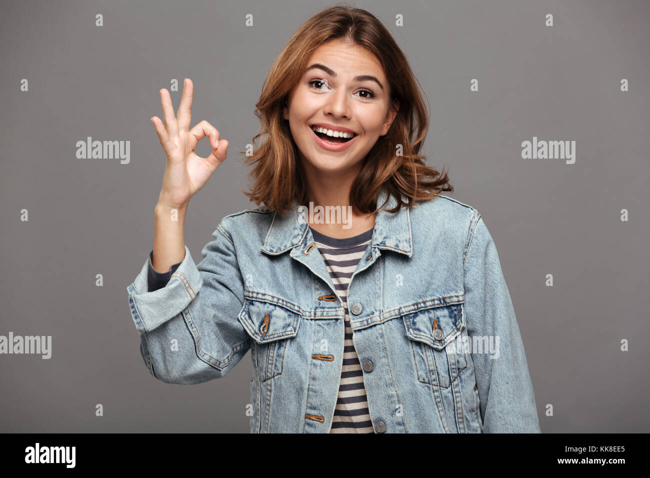 Portrait of a cheerful smiling teenage girl dressed in denim jacket ...