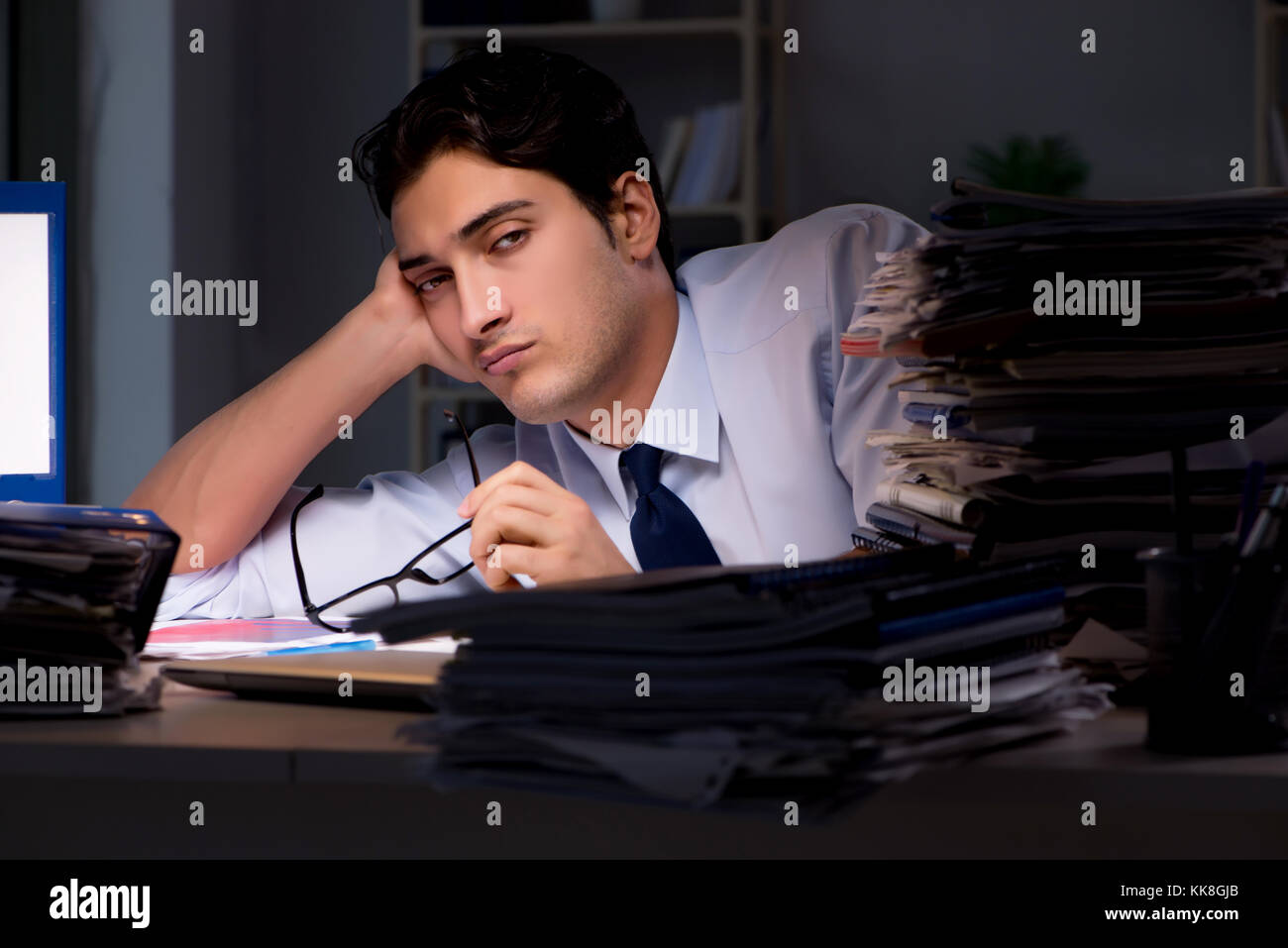 Young businessman working overtime late in office Stock Photo - Alamy
