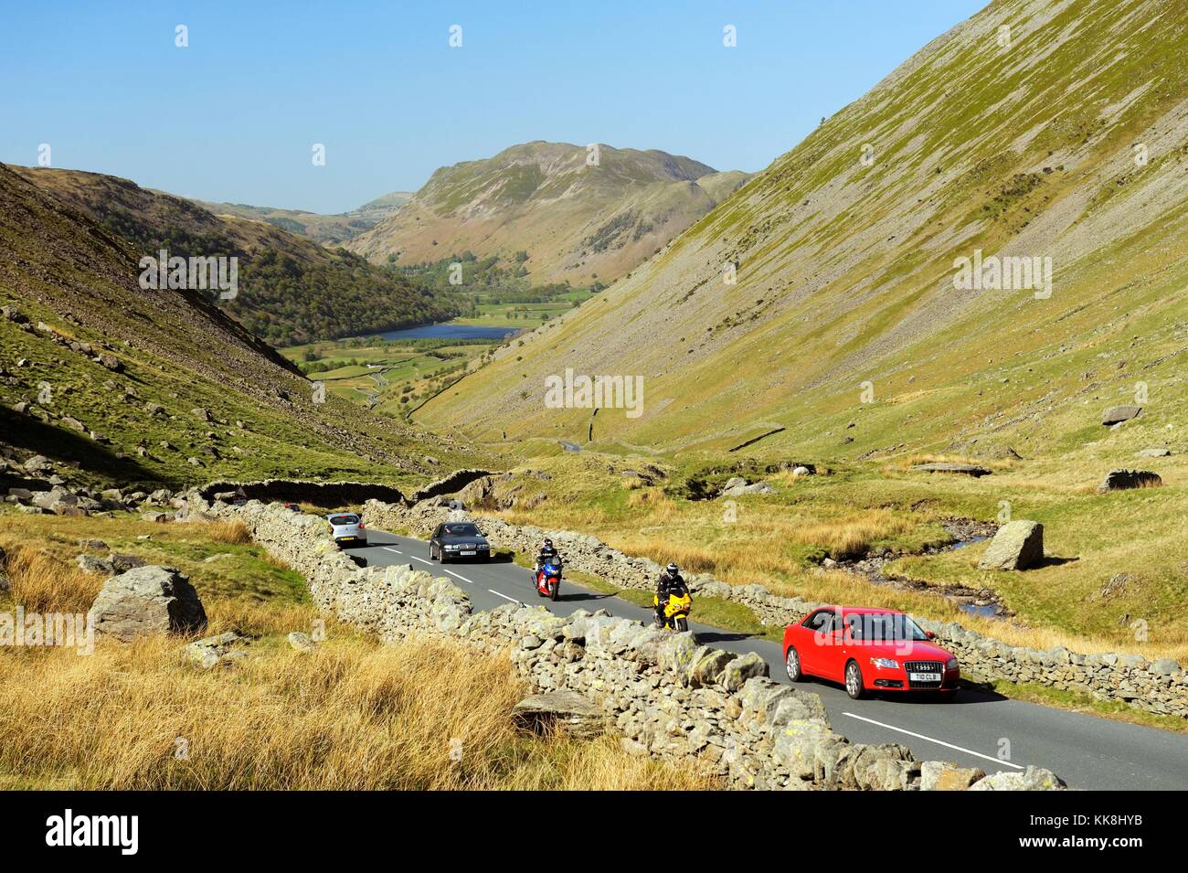 Kirkstone Pass, Cumbria, England. Traffic climbs Kirkstone Pass from Brotherswater, Patterdale in distance toward Ambleside Stock Photo