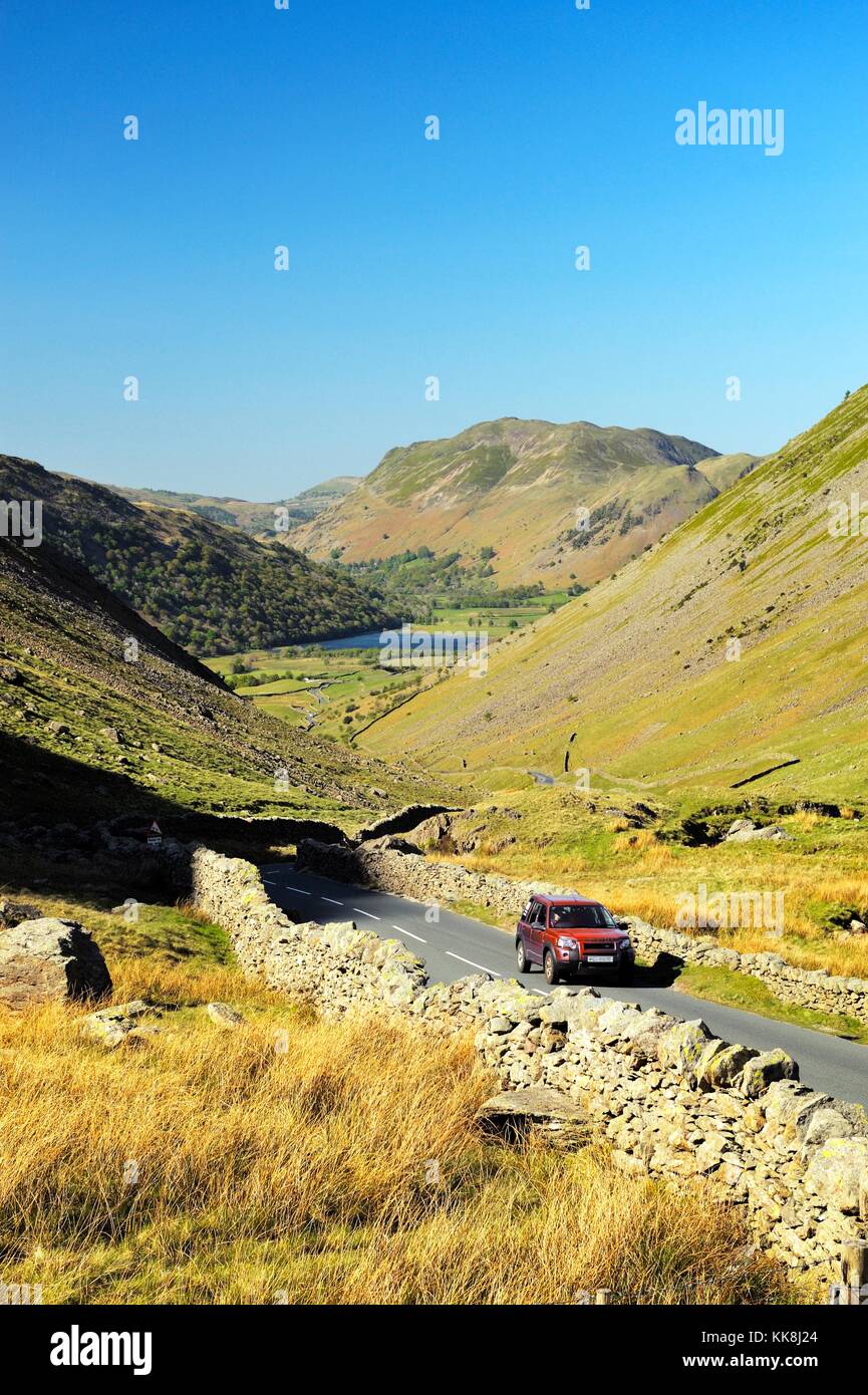 Kirkstone Pass, Cumbria, England. Traffic climbs Kirkstone Pass from Brotherswater, Patterdale in distance toward Ambleside Stock Photo