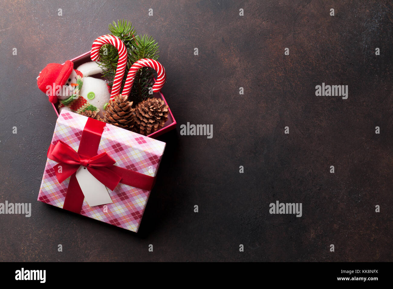 Christmas gift box with candy cane, snowman toy and snow fir tree on ...